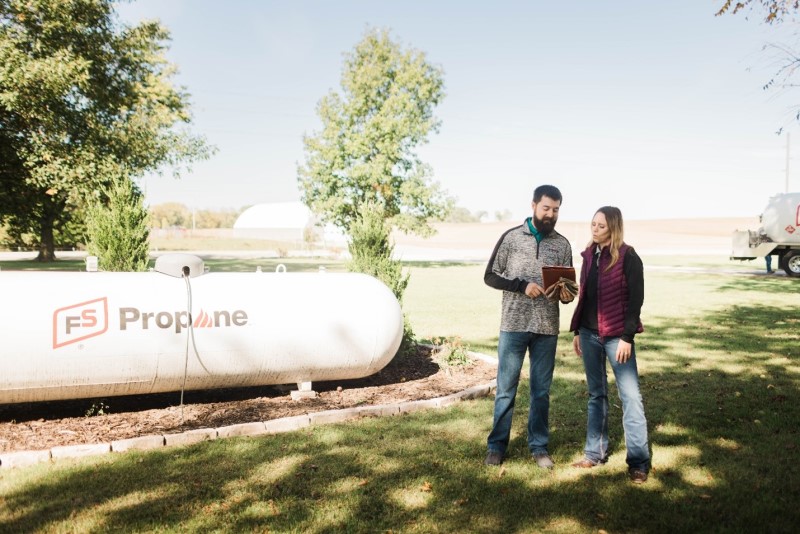 propane specialist assisting homeowner in front of fs propane tank propane specialist assisting homeowner in front of fs propane tank