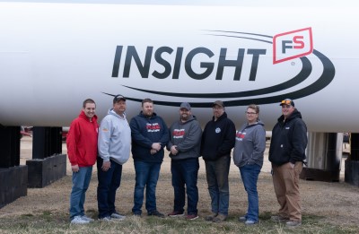 Insight FS employees and Cobb-Eden fire district volunteers pose in front of an Insight FS tank